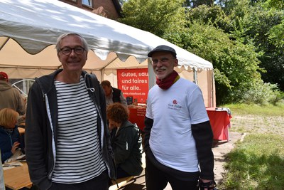 Tag der Fische 20226, Jörg Kleine (CV Hamburg) und Frank Buchholz (CV Lübeck) © Slow Food Deutschland Zwei Männer stehen lächelnd vor einem Slow-Food-Zelt