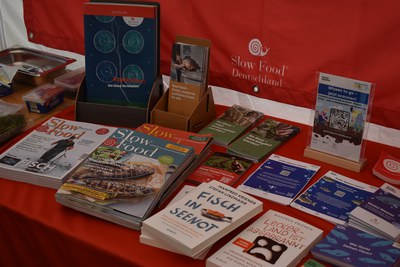 Tag der Fische 2026, der Slow-Food-Infostand mit Magazinen, Broschüren und Krieners Buch "Fisch in Seenot" © Slow Food Deutschland Infostand mit Slow-Food-Magazinen, Flyern und dem Buch "Fisch in Seenot"