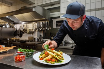 Raimund Stuckatz richtet in der Küche ein Spargelgericht mit frischen Kräutern an
